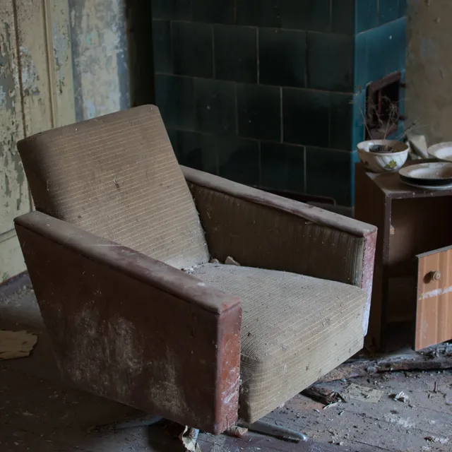 Old reclining chair next to an old nightstand