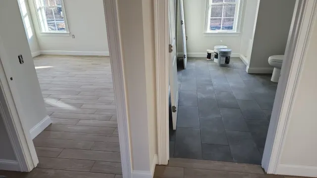 Finished dark tile floor extending through a hallway