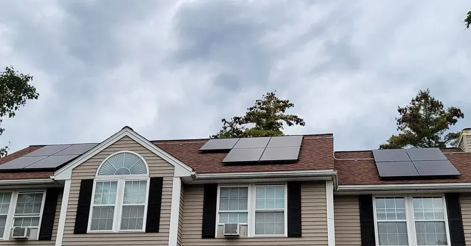 A house with a lot of windows and solar panels on the roof.