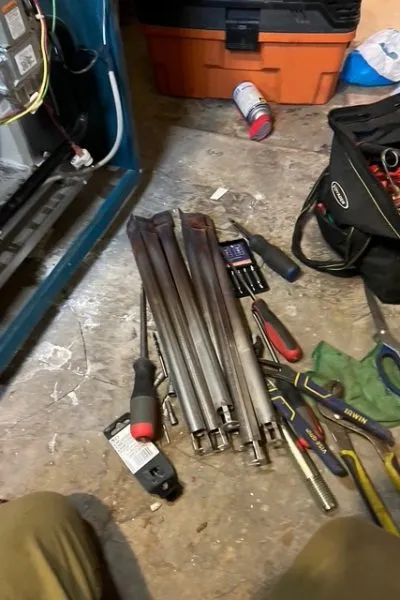 Toolbag, screwdrivers, and metal rods on floor