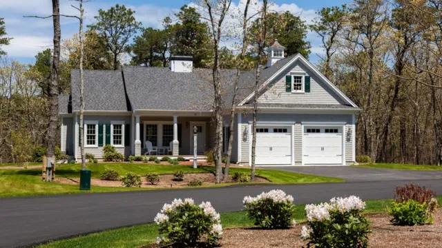 Gray single-story Windward Village house with double garage, porch, lawn, and garden – McPhee Associates of Cape Cod.