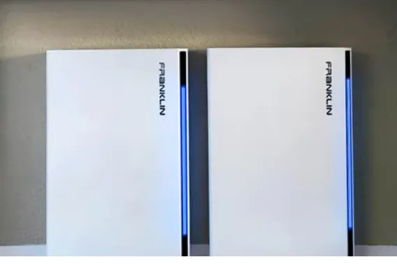 Two white electronic devices, possibly routers or modems, with blue indicator lights on a beige surface.