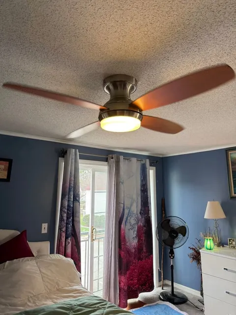 A ceiling fan with an integrated LED light installed and balanced in a bedroom.
