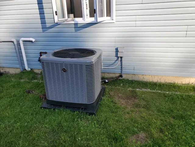 Outdoor air conditioning condenser installed beside a home