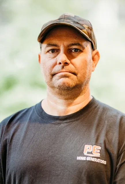 Man wearing a PE Home Generators t-shirt and a cap.