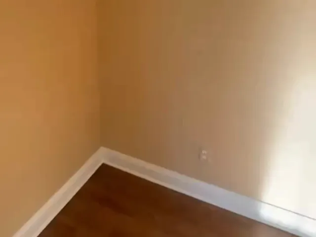 Interior wall painting showing finished corner, baseboard, and smooth wall surface with clean lines