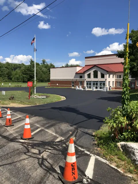 Freshly paved parking area outside a public building.