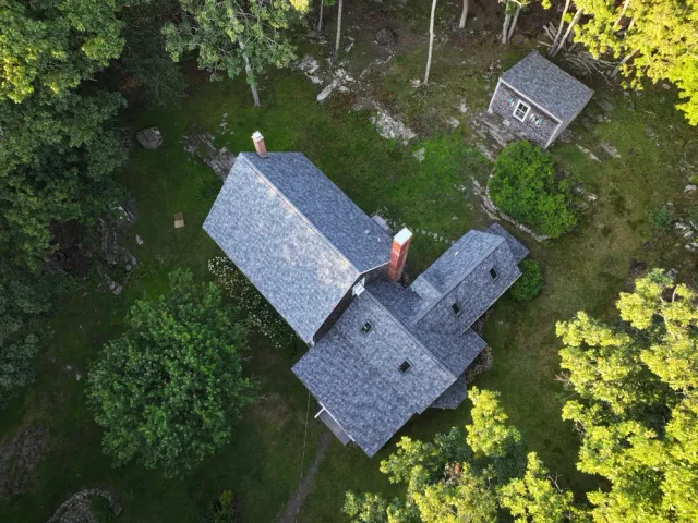 Aerial view of house and shed among trees
