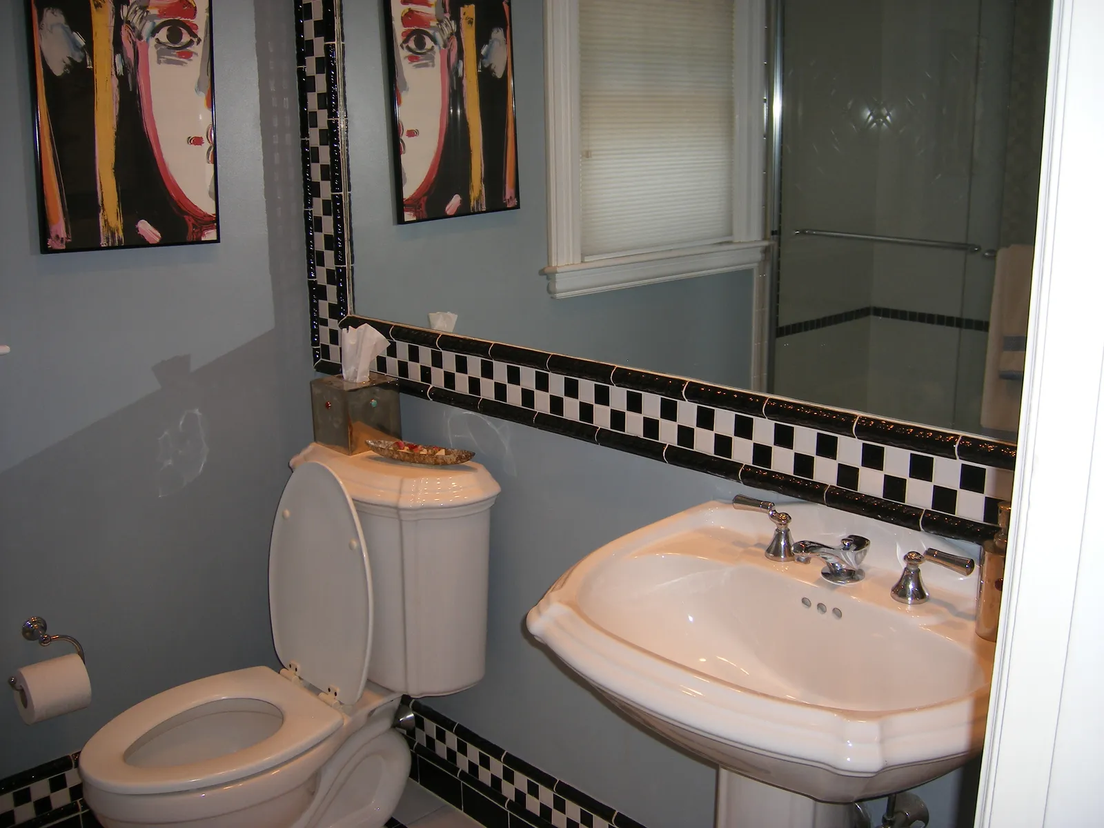 Finished lower-level half bath with pedestal sink and tiled mirror surround