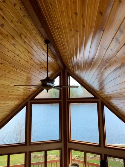 Vaulted wooden ceiling and large windows overlooking a lake