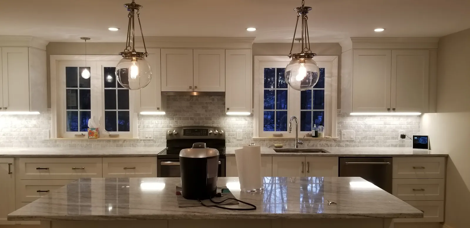 Finished kitchen with glass globe pendants and under-cabinet lights