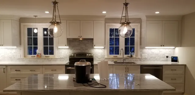 Finished kitchen with glass globe pendants and under-cabinet lights
