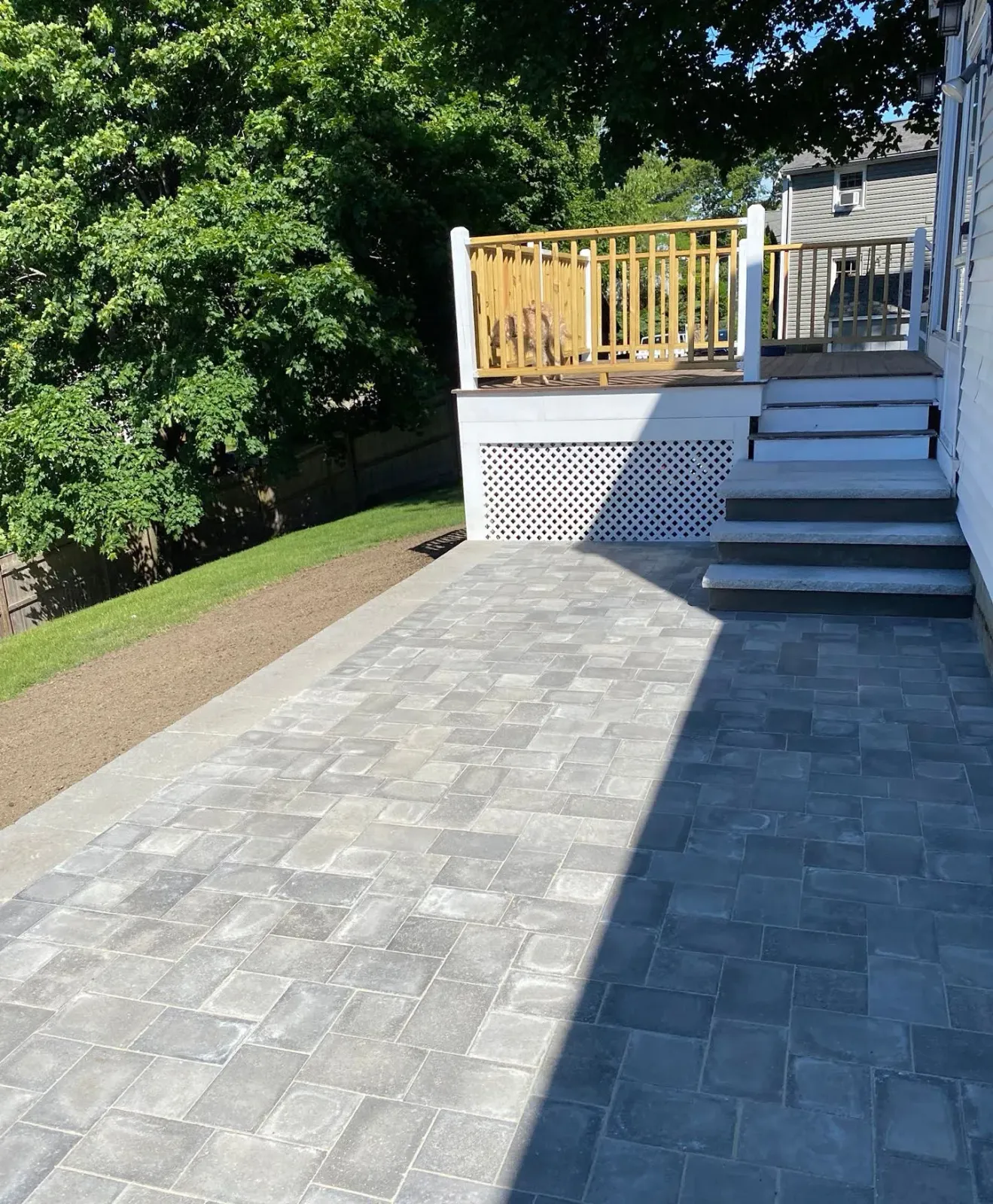 A brick walkway leading to a deck with a yellow railing