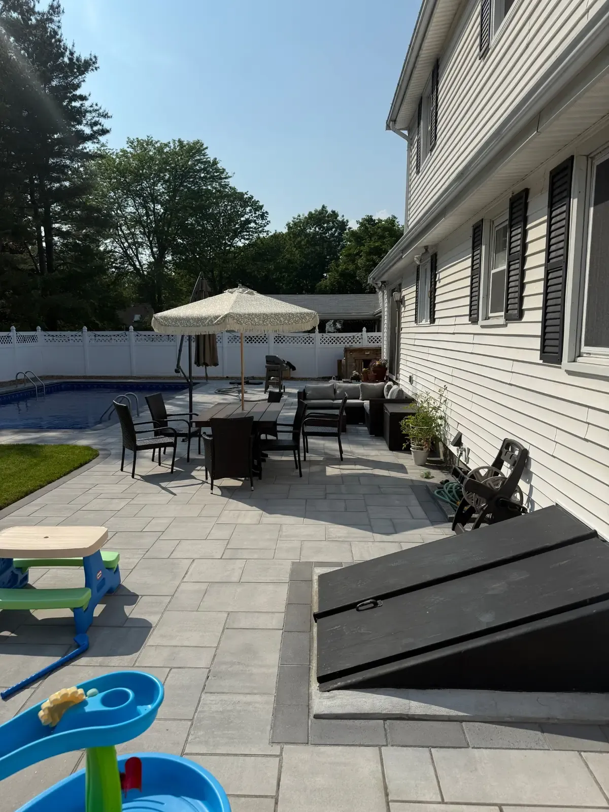 Paver patio installation creating an outdoor living space at a home in the Greater Boston area.