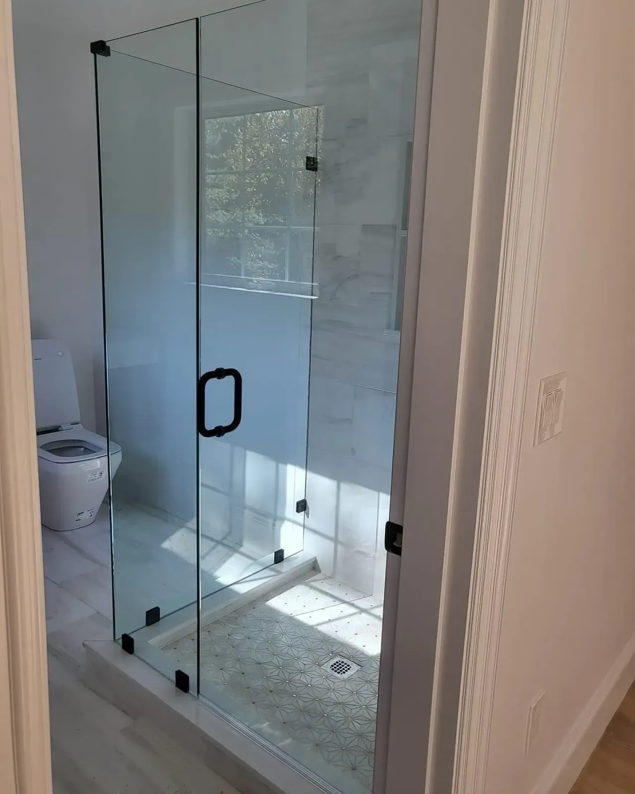 Finished glass shower enclosure with dark hardware