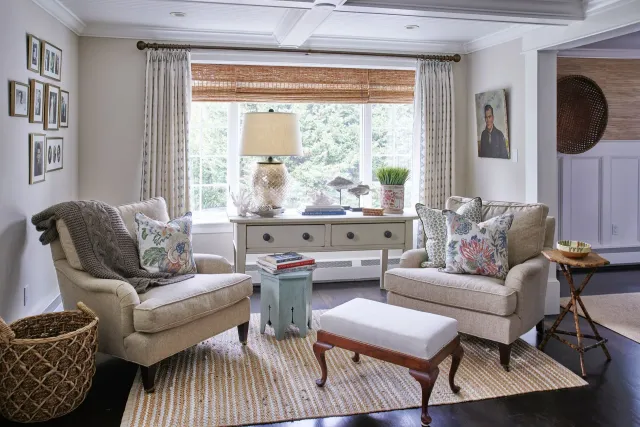 Cozy living room with two armchairs, a window, and decorative elements in neutral tones.