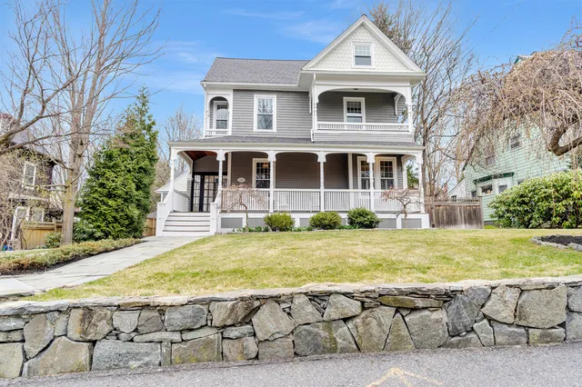Restored Victorian exterior with wraparound porch and stone wall