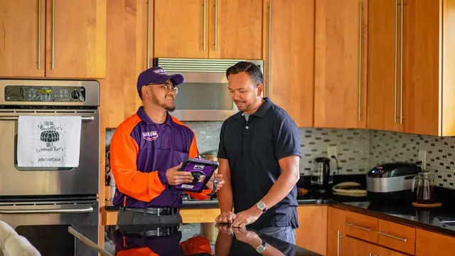 A New Era team member talks to a client in a kitchen