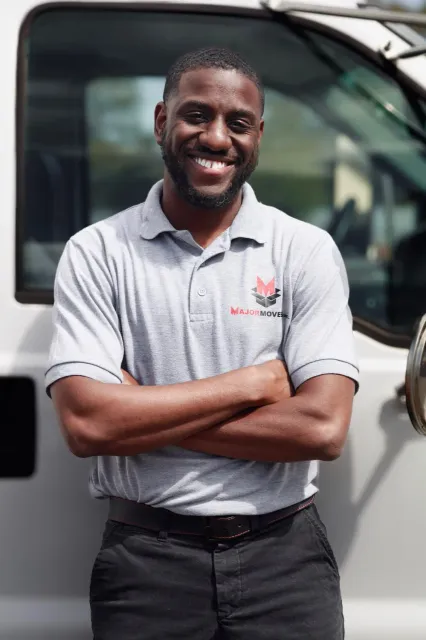 A Major Movers team member in a branded polo beside a white truck