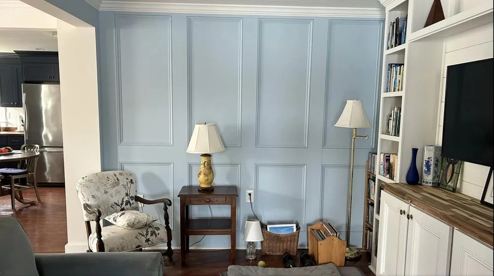 Paneled accent wall with built-in cabinetry lighting and outlets