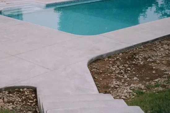 Light gray concrete pool deck new construction