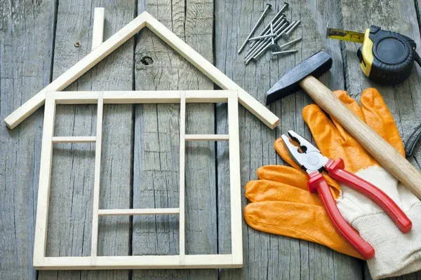 Home Improvement - house made out of wood with gloves & tools around
