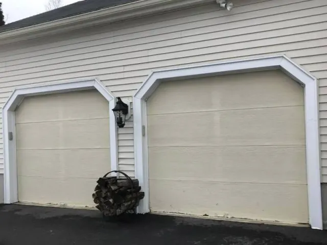 A couple of garage doors with arches on the side of a house