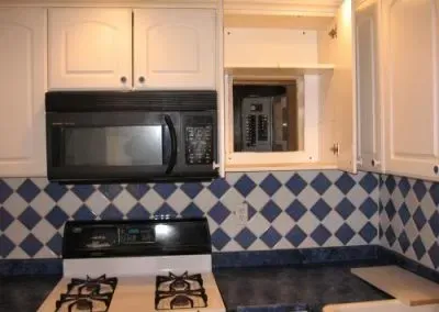 Not acceptable to hide the electrical panel behind a cabinet. Should be readily accessible