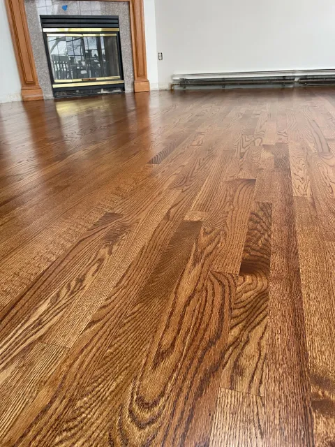 Close-up of a wood floor with reddish-brown parquet pattern and visible wood grain.