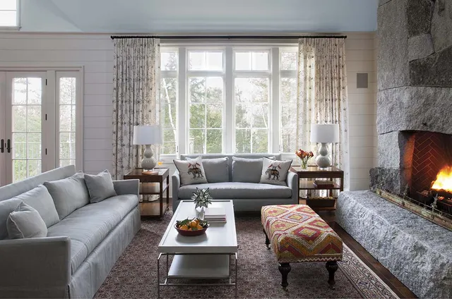 A living room with couches, tables and lamps.