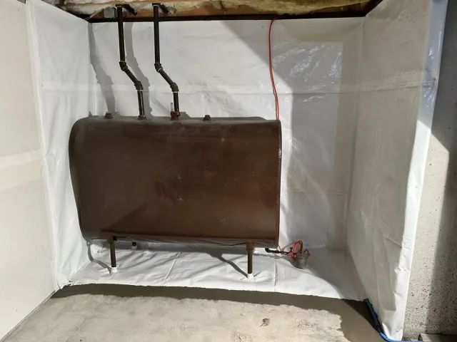 Brown tank with pipes in a white-walled utility room