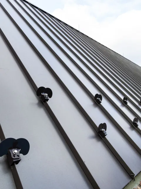 A close up of a metal roof with screws on it