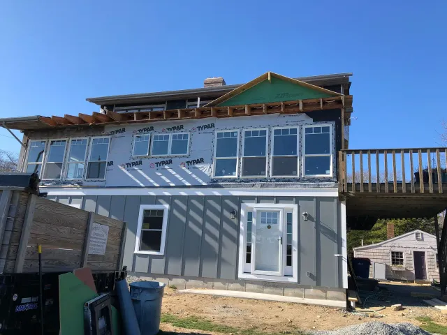 A house is being built with a lot of windows and a deck.