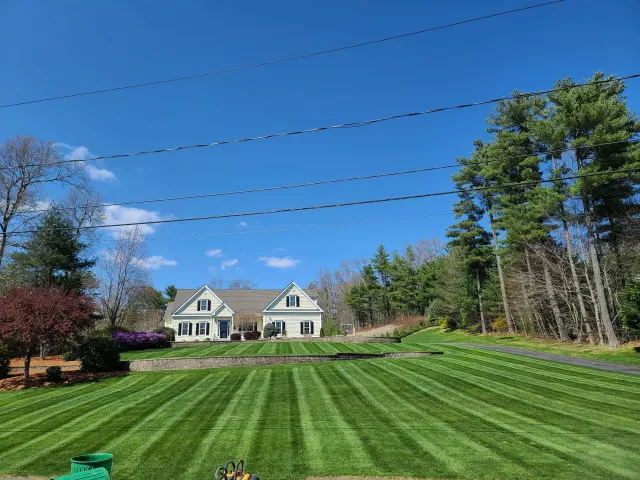 A large house is sitting on top of a lush green lawn.