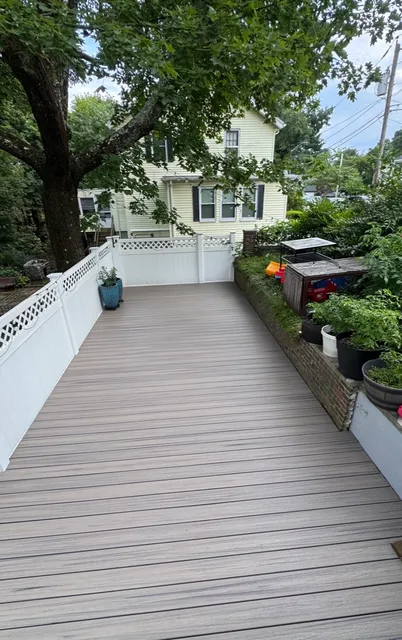 Composite deck with white vinyl privacy railings and planters