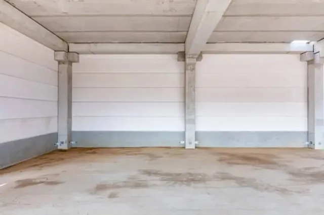 Remodeled residential garage interior with finished walls and sealed floor coating