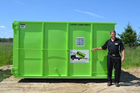 A man stands next to a Bin There Dump That dumpster bin