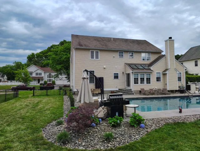 Backyard with paver patio, pool and fresh landscaping completed by Sunnyside Property Services in New Haven County, CT