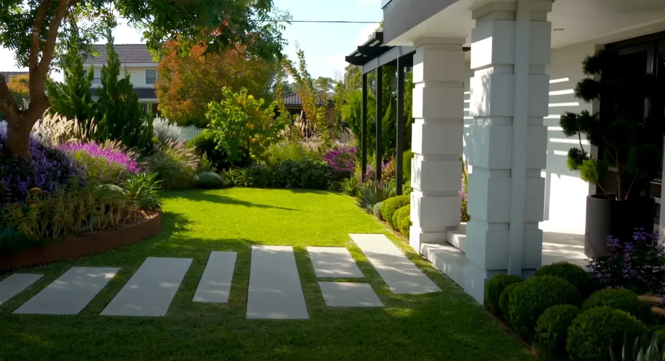 Modern landscape design with concrete pavers and colorful flower beds in Brookline, MA