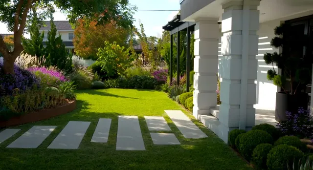 Modern landscape design with concrete pavers and colorful flower beds in Brookline, MA