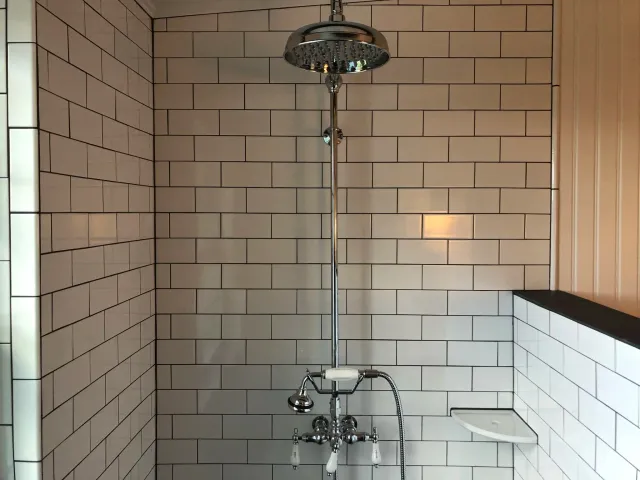 Modern shower with white subway tiles on walls, chrome fixtures, and a rainfall showerhead.