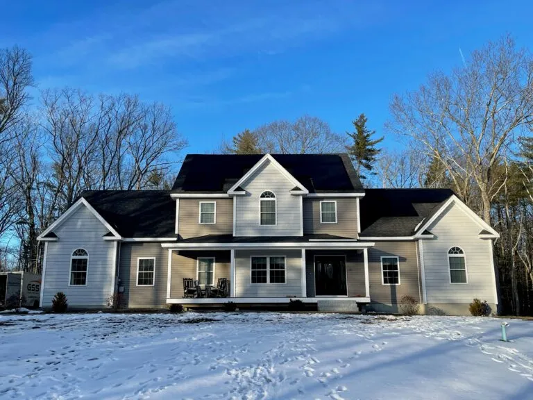 Granite State Solar rooftop solar array on a large New Hampshire home in winter, showing solar panels work year-round in NH.