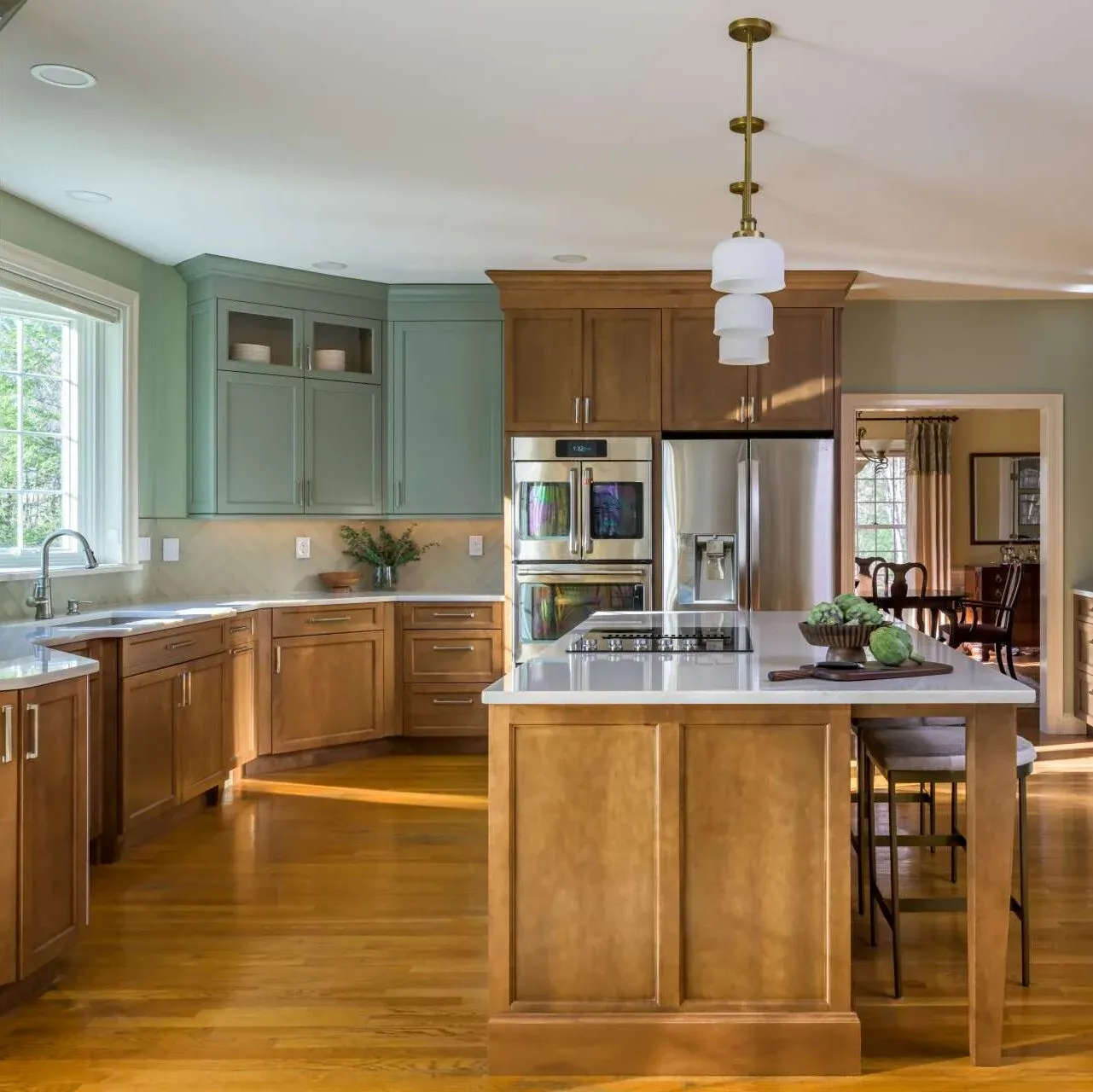 A cozy kitchen with wooden flooring and vibrant green cabinets, enhancing the space's charm.