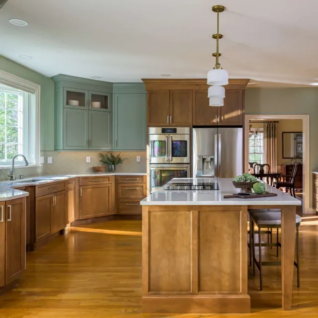 A cozy kitchen with wooden flooring and vibrant green cabinets, enhancing the space's charm.