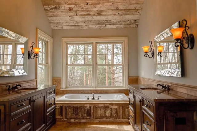A master bathroom with sinks and a tub