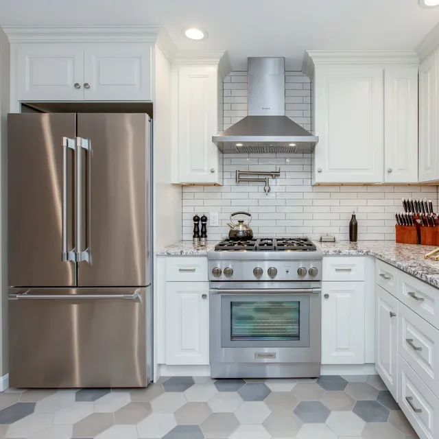 Kitchen remodel in Portsmouth, NH with custom cabinetry, granite countertops, Thermador gas range, Faber stainless steel vent hood, and subway tile backsplash