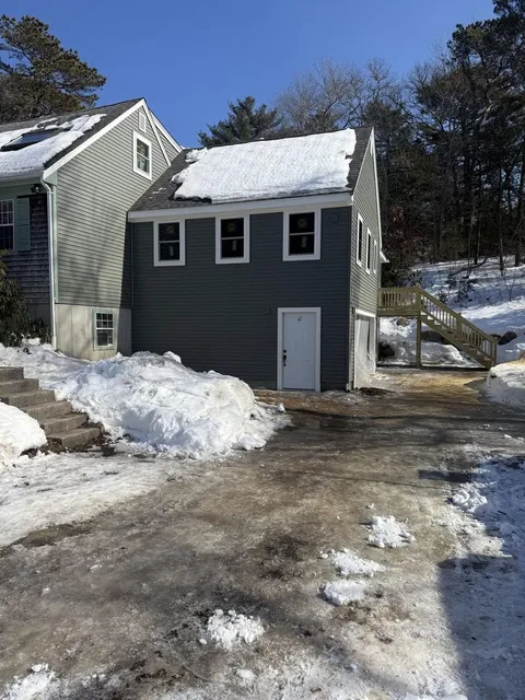 Completed two-story home addition with dark siding and custom stairway — Perocchi Building & Remodeling, South Shore MA