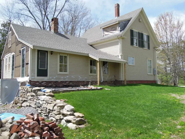The rear of the home shown with new roof, roof extension, and 2nd story dormer in progress.