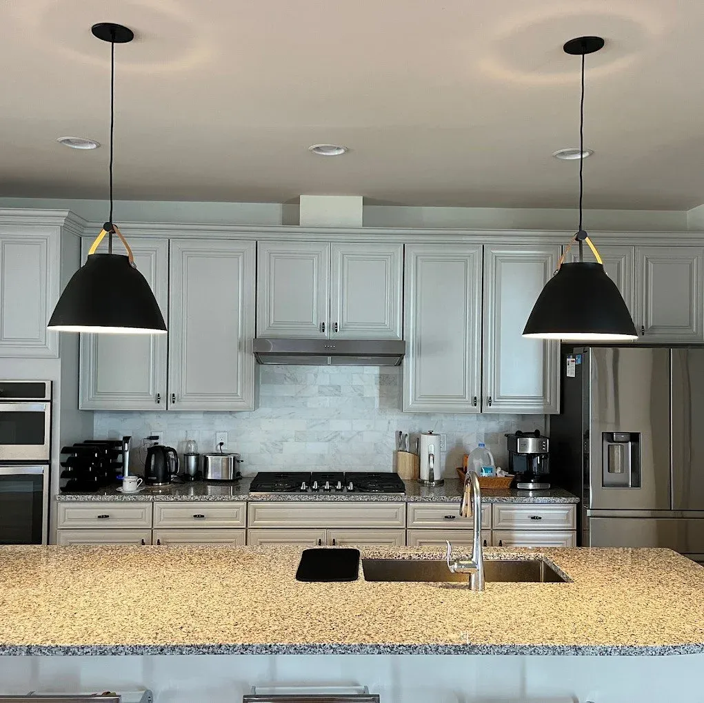 wo perfectly installed black modern pendant light fixtures above a kitchen island