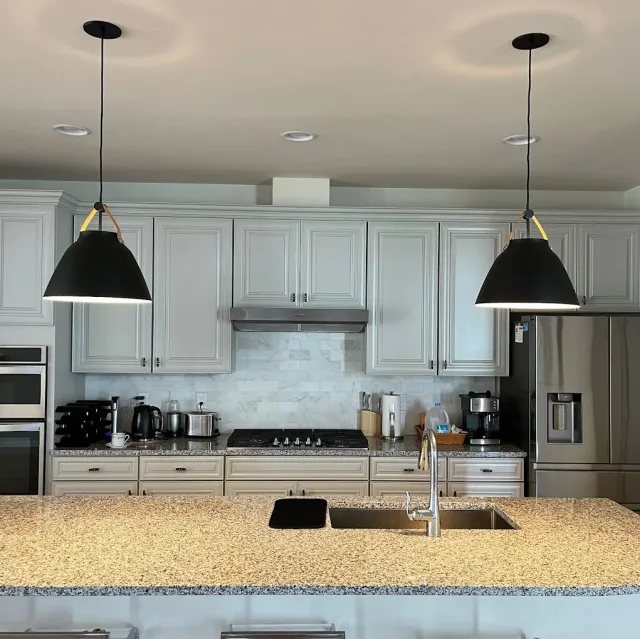wo perfectly installed black modern pendant light fixtures above a kitchen island